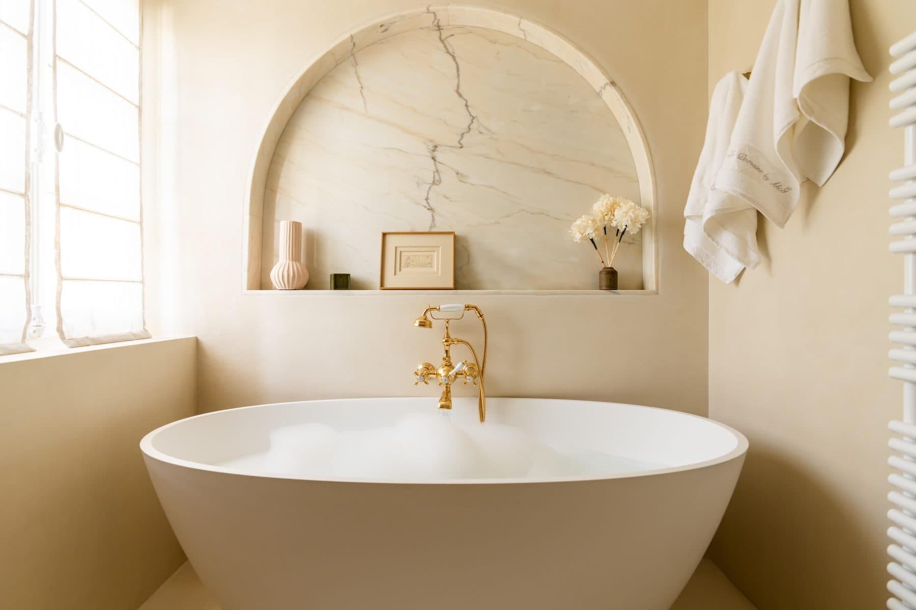 Baignoire îlot sous une niche de marbre