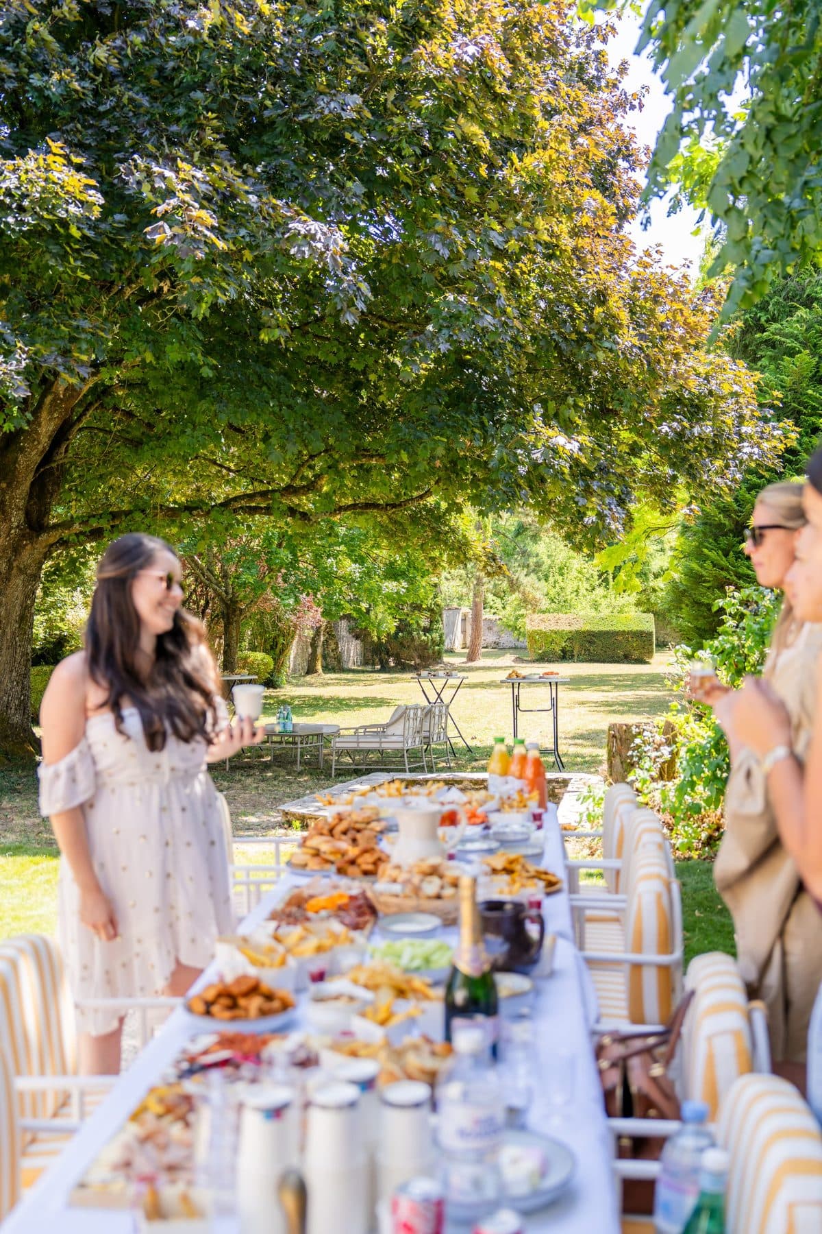 Grande tablée de brunch dressée sous les arbres